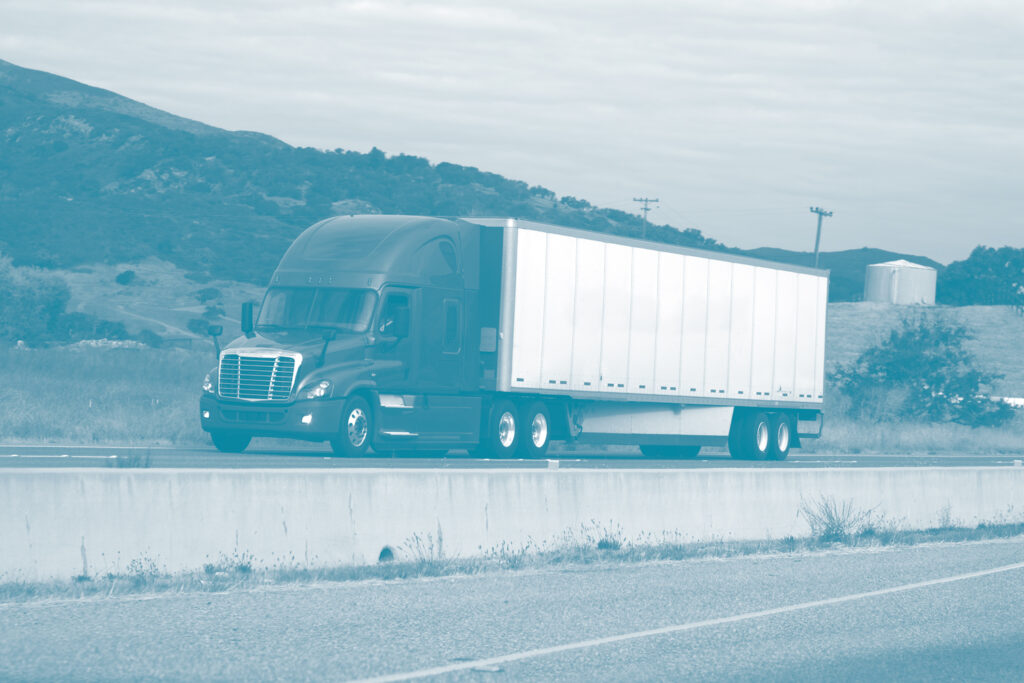 A diesel truck and trailer hauling a load on the highway that may be utilizing freight logistics for delivery similar to those used by E&E Logistics Co. LLC in Fresno, CA.